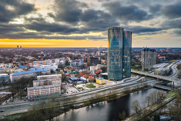 Fototapeta na wymiar Aerial view over Riga city in colorful sunset. Urban landscape with skyscrapers and highway. 