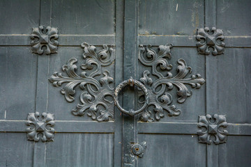 Close-up of ancient vintage metal door with cast iron floral deorative ornament