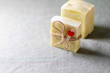 Natural handmade soap with a heart decor on a background of linen fabric.
