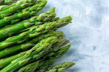 Young green asparagus closeup. Copy space on a light gray background.