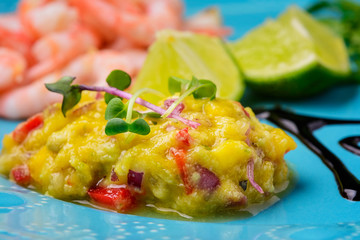 Tasty sauce of mango and hot pepper close-up. Chutney on a blue plate. National cuisine.