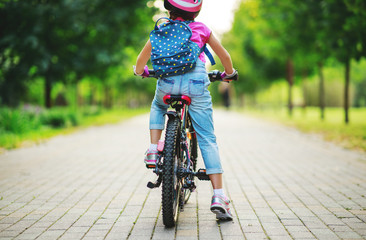 happy cheerful child girl riding a bike in Park in nature.