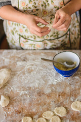 Woman hands dumplings with potatoes on a white background, traditional Ukrainian food.