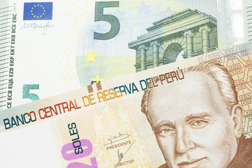 A pastel colored, twenty Peruvian sol bank note, close up in macro with a red, European five euro bill
