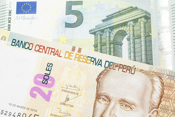 A pastel colored, twenty Peruvian sol bank note, close up in macro with a red, European five euro bill
