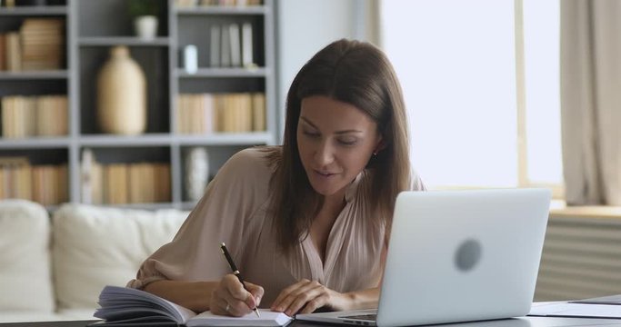 Smiling female online tutor wear earphone speaking teaching web class