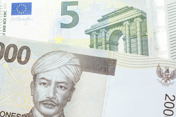 A gray two thousand Indonesian rupiah bank note with a five Euro note 