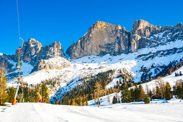Fototapeta na wymiar Ski lift and slope in Dolomites mountains, Italy
