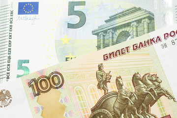 A close up image of a one hundred Russian ruble bank note close up with a five Euro bank note