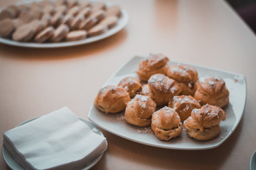 bollos dulces, repostería sobre plato blanco en mesa de madera