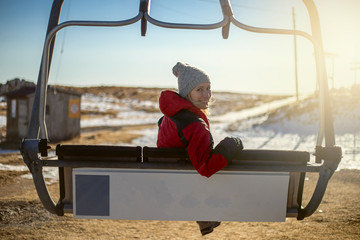 Woman looks at camera in chairlift in mountain