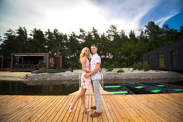 A loving young couple is hugging on a wooden pier