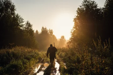 Foto op Plexiglas Zomer jacht bij zonsopgang. Hunter beweegt met Shotgun en zoekt naar prooi. © romankosolapov