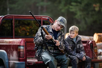 Schilderijen op glas Father teaches his grandson to hunt in a woods © romankosolapov
