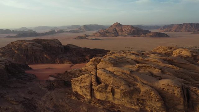Wadi Rum mountain landscape at sunset, Jordan, aerial pull back