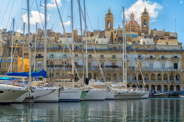 Sailboats sitting in the port in front of old city