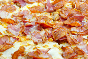 Close up of Pizza Texture. Pizza with ham, cheese, mashrooms, paprika, salami. top view of pizza for any background.