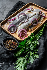 Traditional Dutch food herring with red onion. New season of herring called Hollandse nieuwe. Black background. Top view