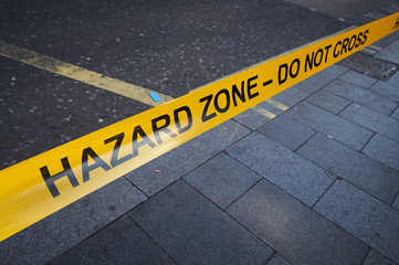 Hazard zone police tape on sidewalk