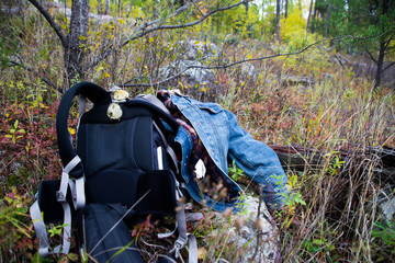 Hikers jean jacket and backpack on the ground during rest