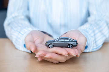 toy car in the hands of women. Protecting the security concept.