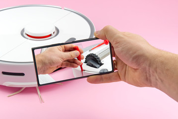 white robot vacuum cleaner. Vacuum cleaner robot repair concept on pink background. technology robot