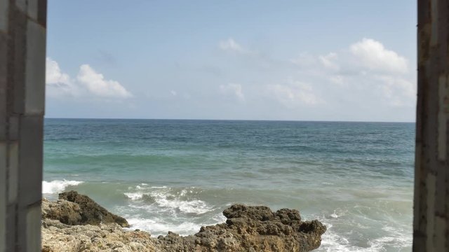 K&uuml;ste mit blauem Wasser und felsen, aufnahme durch Steinfenster in Calla Millor auf Mallorca, Spanien