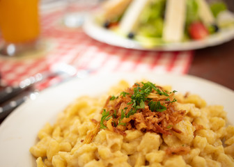 Close up of Kässpätzle (traditional Bavarian dish) on restaurant table