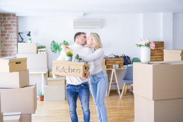 Fototapeta na wymiar Young beautiful couple kissing moving cardboard boxes at new home