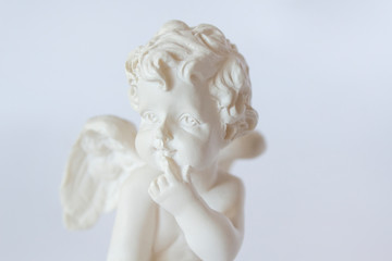 statue of amour angel curious cupid face on white background