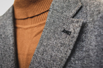 Close up of mens grey wool blazer combined with brown fashionable polo.  Low DOF. Selective focus.