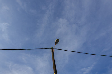 street lamp turned off by day over blue sky