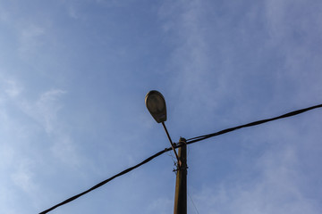 street lamp turned off by day over blue sky