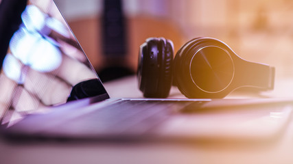 Obraz na płótnie Canvas Close-up shots at the black wireless music headphones on the desk.