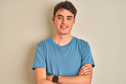 Teenager boy wearing casual t-shirt standing over isolated background happy face smiling with crossed arms looking at the camera. Positive person.