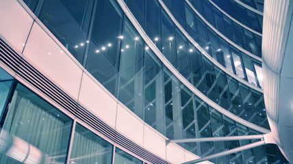 Night architecture - building with glass facade. Modern building in  business district. Concept of economics, financial. Photo of commercial office building exterior. Abstract image of office building