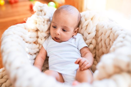 Adorable baby lying down over blanket on the floor at home. Newborn relaxing and resting comfortable