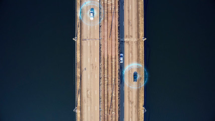 Autonomous self-driving cars on city bridge, aerial top view. Driverless autos and artificial intelligence system with sensors wireless communication. Future transportation technology concept.