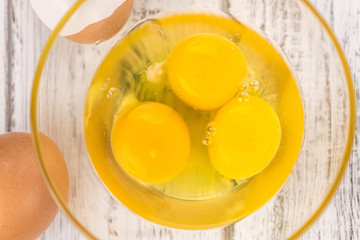 Wooden table with Raw Eggs (detailed close-up shot; selective focus)