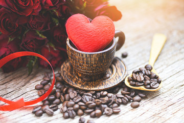 Heart in wooden coffee cup with coffee beans romantic love valentines day and red rose flower on wood background - love coffee concept