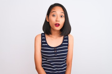 Young chinese woman wearing striped t-shirt standing over isolated white background afraid and shocked with surprise expression, fear and excited face.