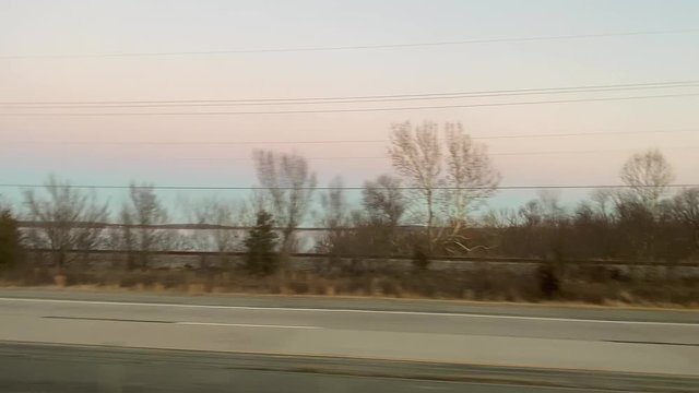 Car driving fast on road at sunset, side view with fast driving cars in opposite direction