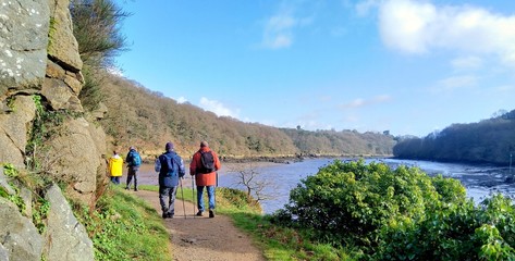 Group of hikers walking along the river at Lannion in Brittany. France
