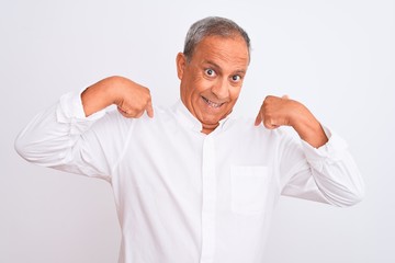 Senior grey-haired man wearing elegant shirt standing over isolated white background looking confident with smile on face, pointing oneself with fingers proud and happy.