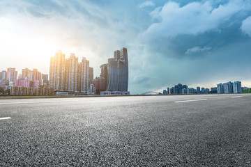 Empty asphalt road and city skyline with buildings in Chongqing at sunset,China.