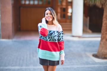 Young beautiful woman smiling happy and confident. Standing and walking at town street