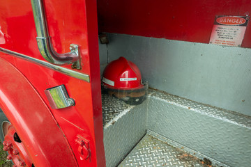 Fototapeta premium An Investigator Helmet in an Old Red Fire Truck