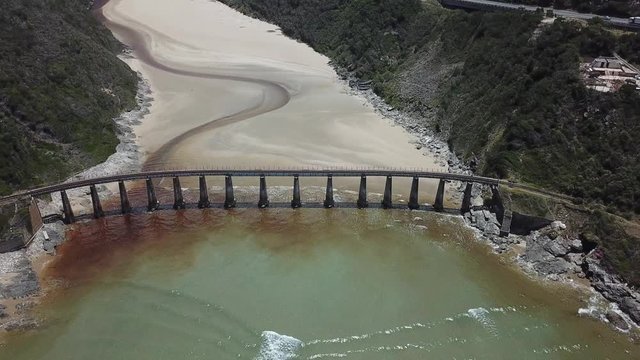 4K summer day aerial video: Kaaimans River Railway Bridge, white sand beach, Kaaimans River mouth. Bridge is located near Wilderness, seaside holiday resort, Garden Route, Western Cape, South Africa
