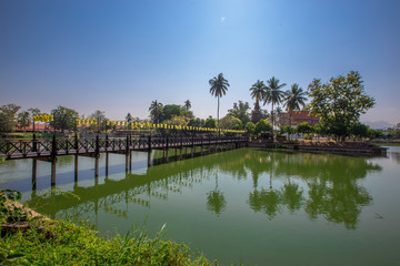 Background of Wat Traphang Thong, which is located in the middle of the water and has a wooden bridge, which is used to organize ceremonies (Loi Krathong, New Year) in Sukhothai province, Thailand.