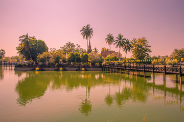 Background of Wat Traphang Thong, which is located in the middle of the water and has a wooden bridge, which is used to organize ceremonies (Loi Krathong, New Year) in Sukhothai province, Thailand.